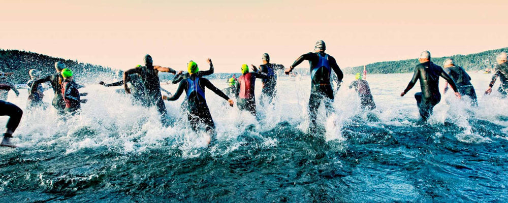 People jumping into the water for an Ironman race