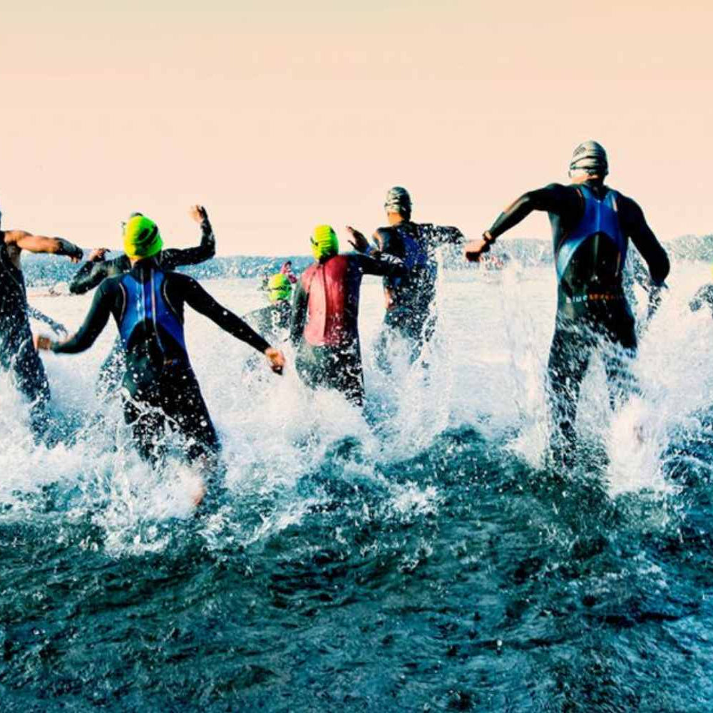 People jumping into the water for an Ironman race